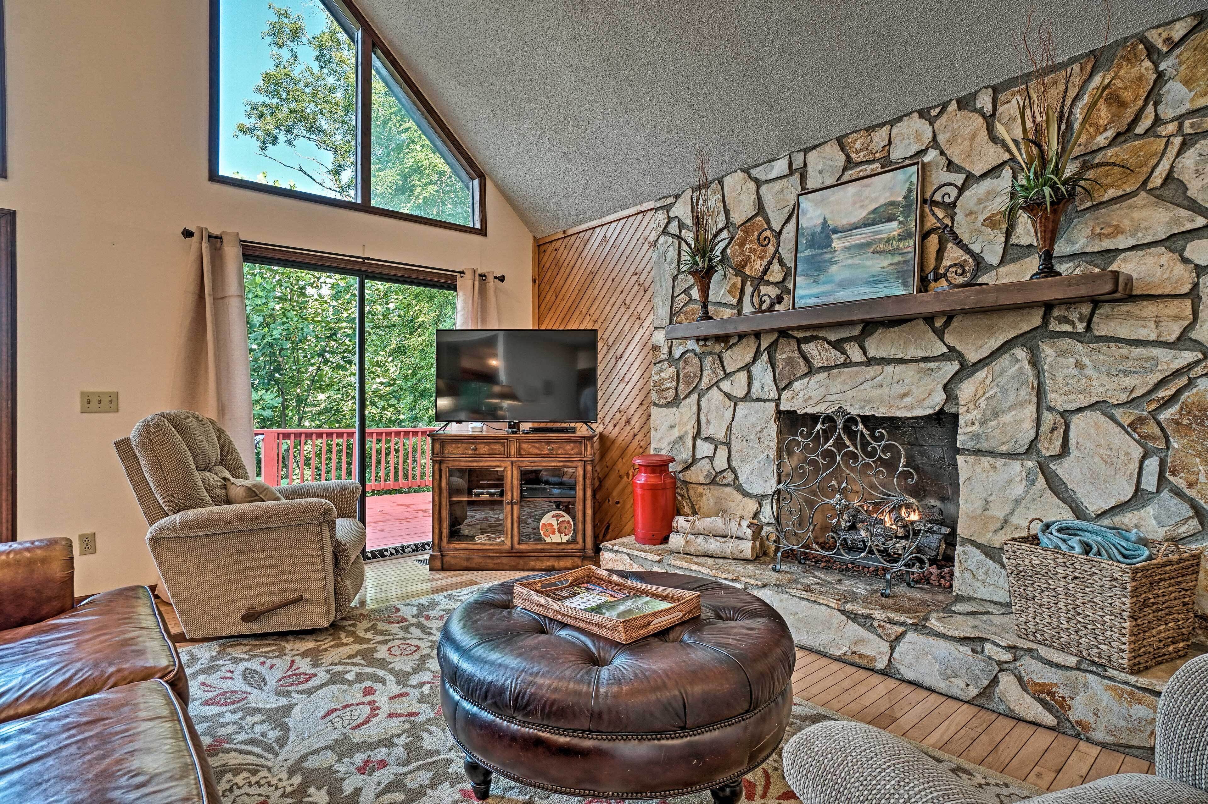 Una sala de estar con chimenea de piedra, televisor y un área de estar acogedora.
