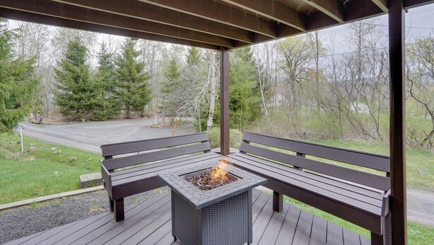 A covered outdoor seating area with a fire feature and benches.
