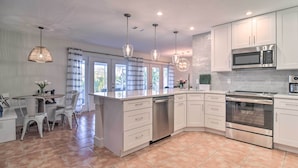 A modern kitchen with white cabinetry, stainless steel appliances, and pendant lighting. - Beach House w/ Pool: 3 Mi to Anna Maria Island! (Bradenton)
