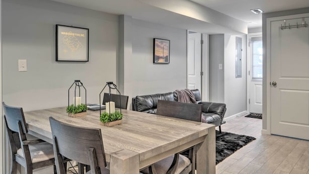 A modern dining area with a wooden table, leather chairs, and a black rug. - 6 Mi to National Mall: Modern DC Apartment! (Washington)