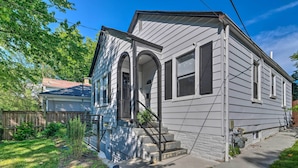 A two-story house with a front porch, a small garden, and a visible garage. - 6 Mi to National Mall: Modern DC Apartment! (Washington)