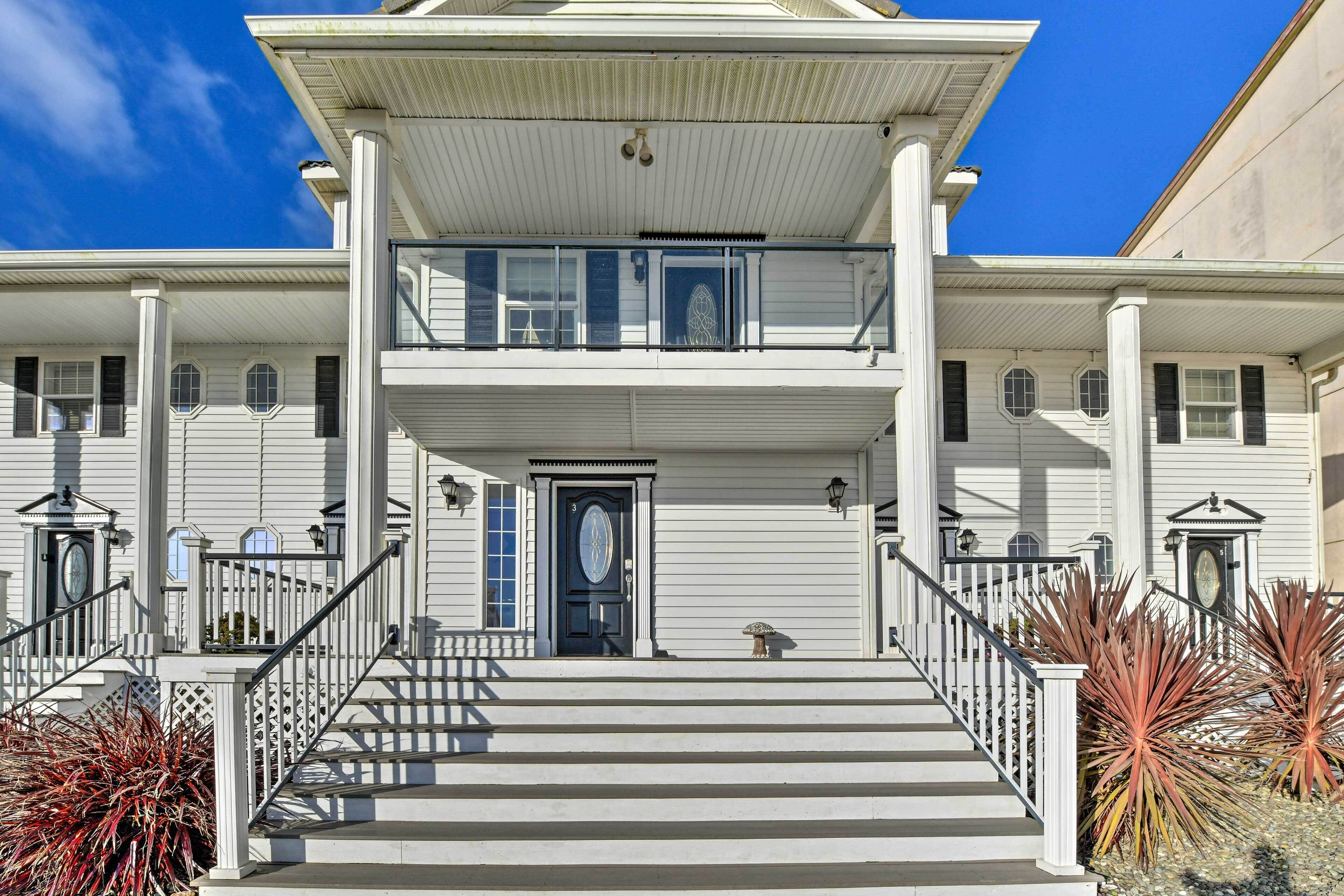 A two-story building with a central entrance, a staircase, and a covered porch area.