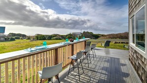 Terraza con mobiliario exterior, barandilla de madera y vista al paisaje.