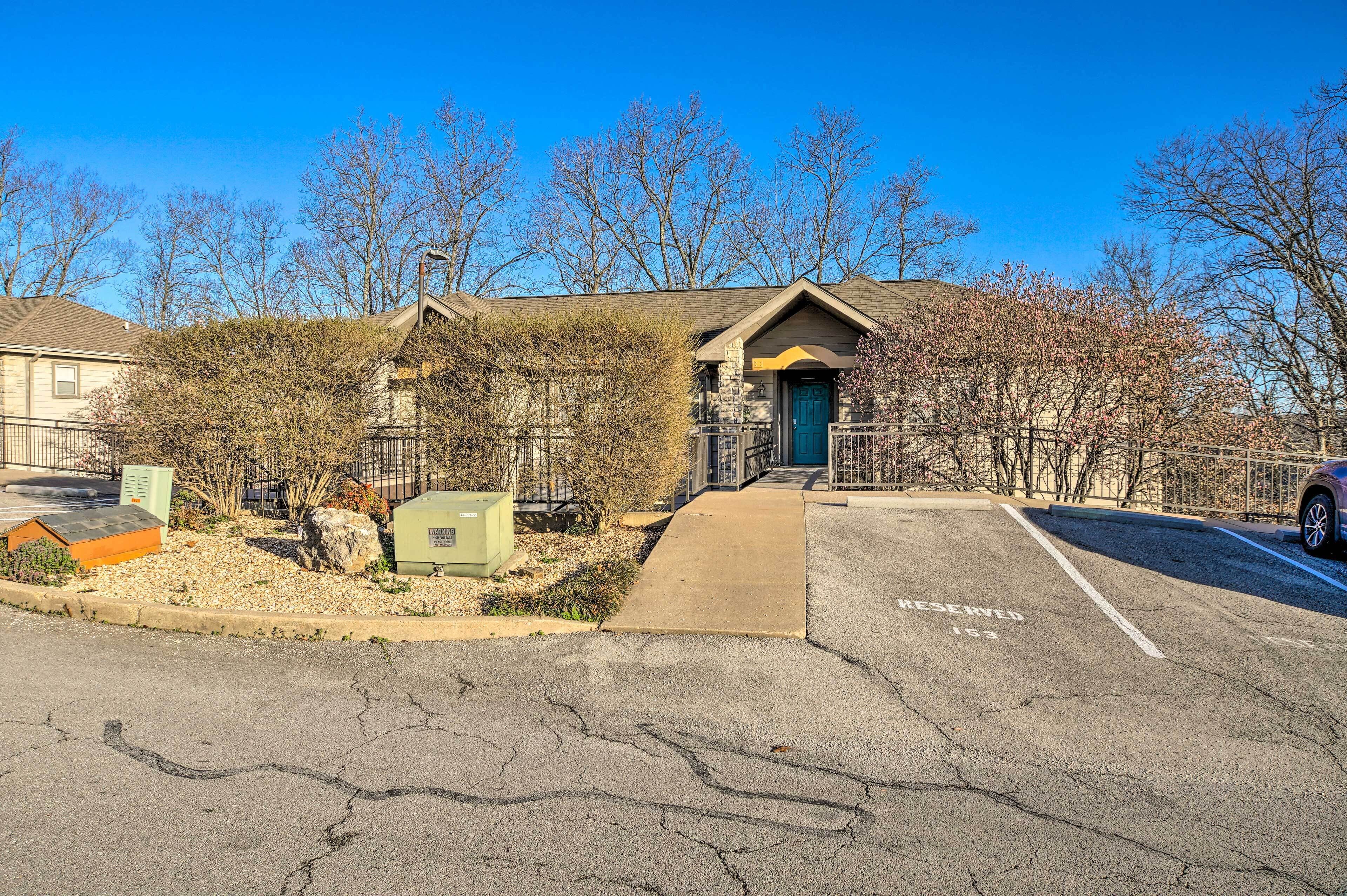 A building with a stone facade, a green door, and a parking area with a 'RESERVED' sign.