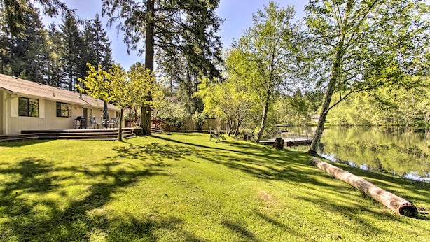 Uma casa com gramado e lago.