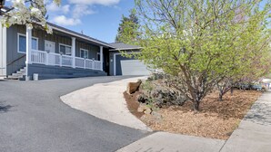 A residential building with a porch, a garage, and a landscaped front yard with a tree. - Bright Bend Home w/ Patio < 3 Mi to Downtown! (Bend)