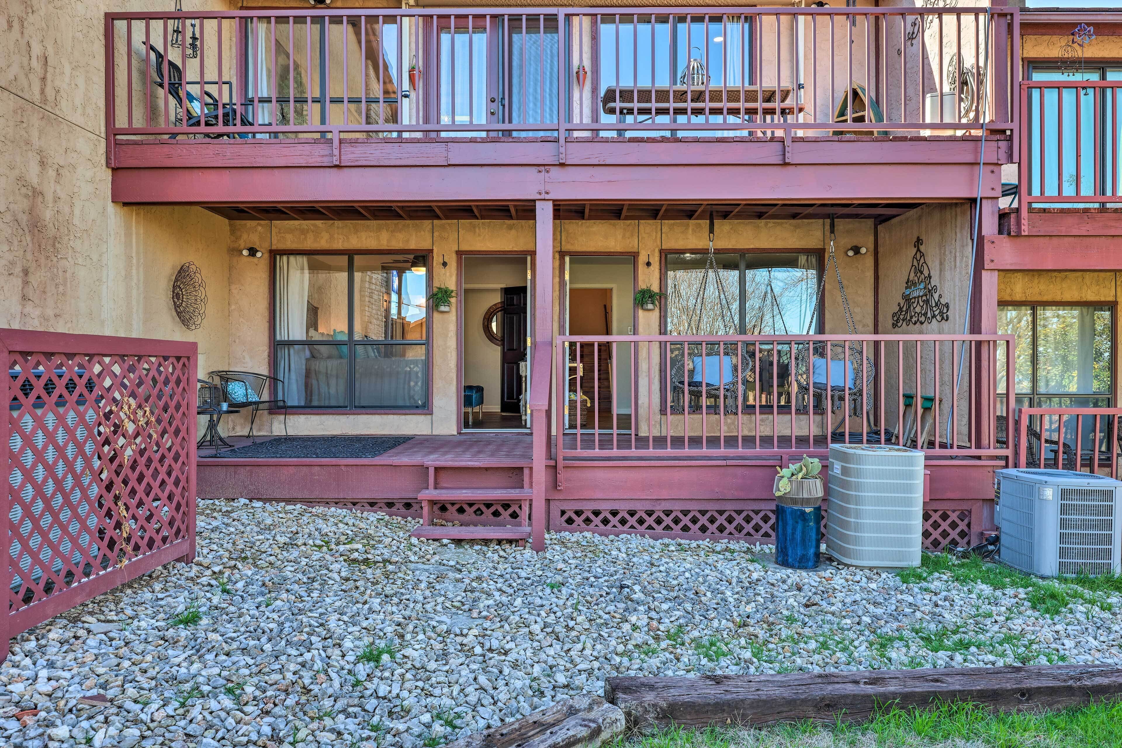 A two-story building with a balcony, a covered porch, and a gravel driveway.