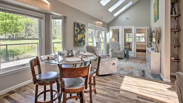 A dining area with a glass table and chairs, a view of the outdoors, and a ceiling with skylights. - All-seasons Chewelah Home: Fish, Golf & Ski! (Chewelah)