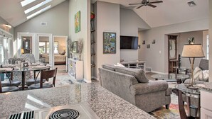 A spacious living area with a high ceiling, skylights, a ceiling fan, and a large flat-screen TV. - All-seasons Chewelah Home: Fish, Golf & Ski! (Chewelah)