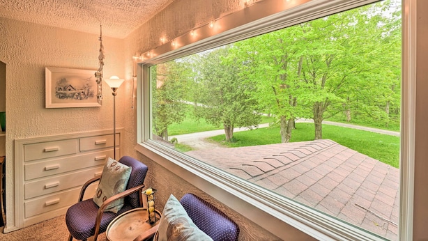 A room with a large window, a ceiling with textured plaster, a framed picture on the wall, and a chair with a cushion. - Door County Retreat ~ 3 Mi to Sister Bay Beach (Sister Bay)