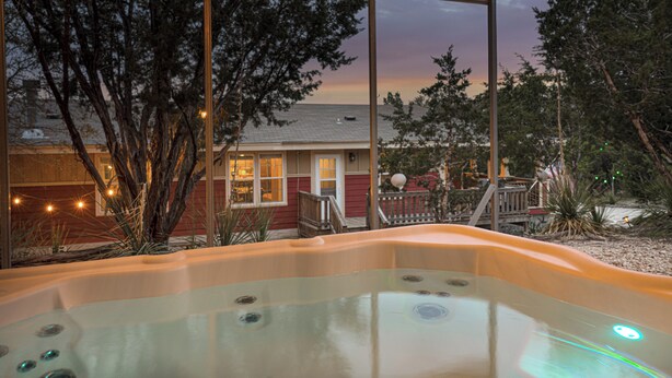 A hot tub with a view of a house and trees. - Hill Country Gem: Sunset Deck, Hot Tub & Fire Pit (Canyon Lake)