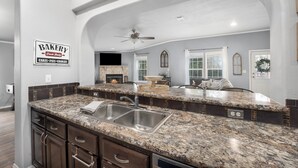 A kitchen with granite countertops, a double sink, and a sign indicating a bakery. - Hill Country Gem: Sunset Deck, Hot Tub & Fire Pit (Canyon Lake)