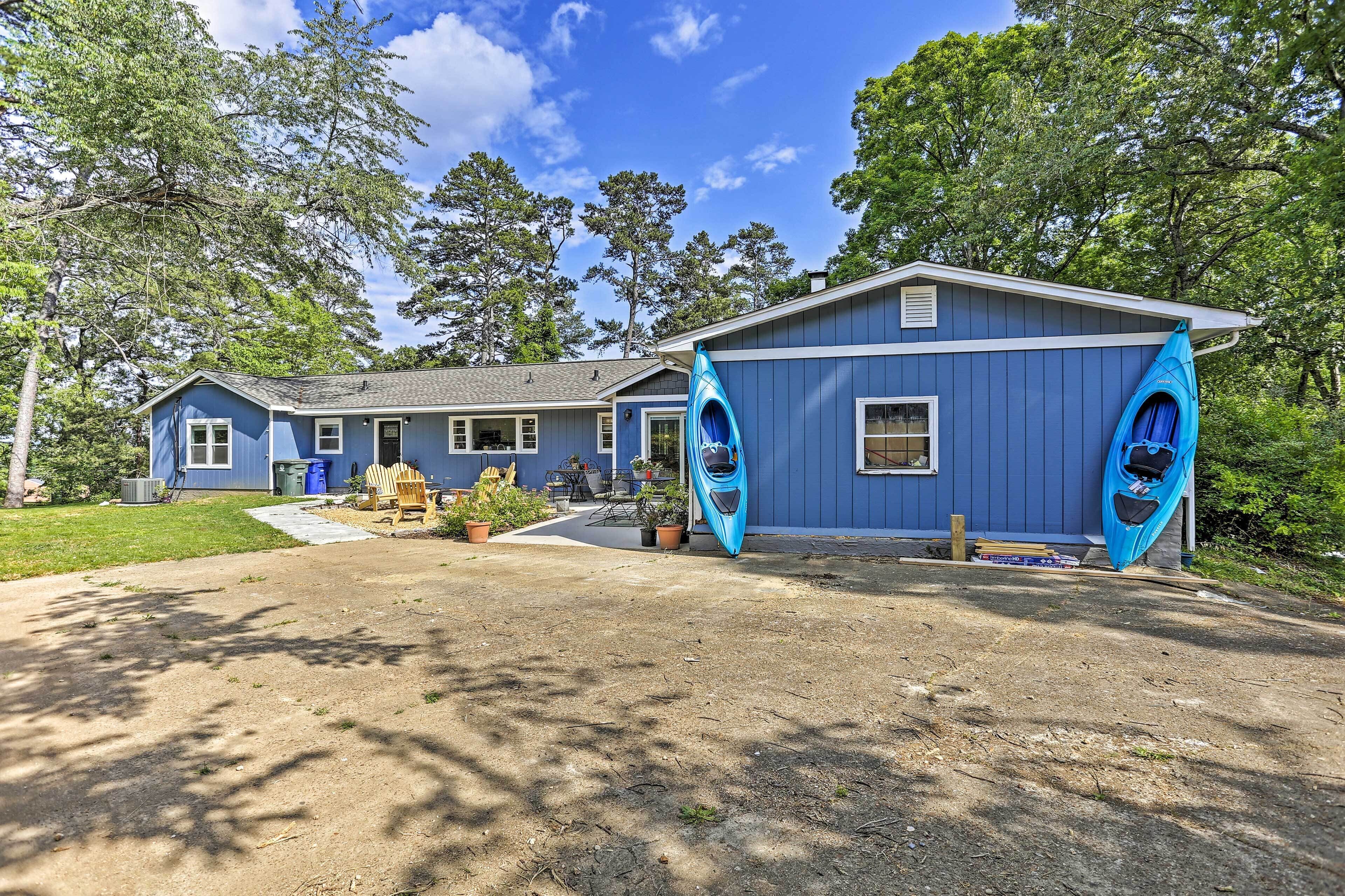 A blue house with a covered porch and two kayaks.