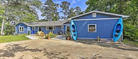 A blue house with a covered porch and two kayaks.