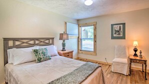 A bedroom with a bed, a chair, a nightstand, a lamp, a window, and a picture on the wall. - Well-appointed Fruita Townhome: Hike & Bike Nearby (Fruita)