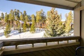 Un balcone in legno con vista su un paesaggio innevato e pini.
