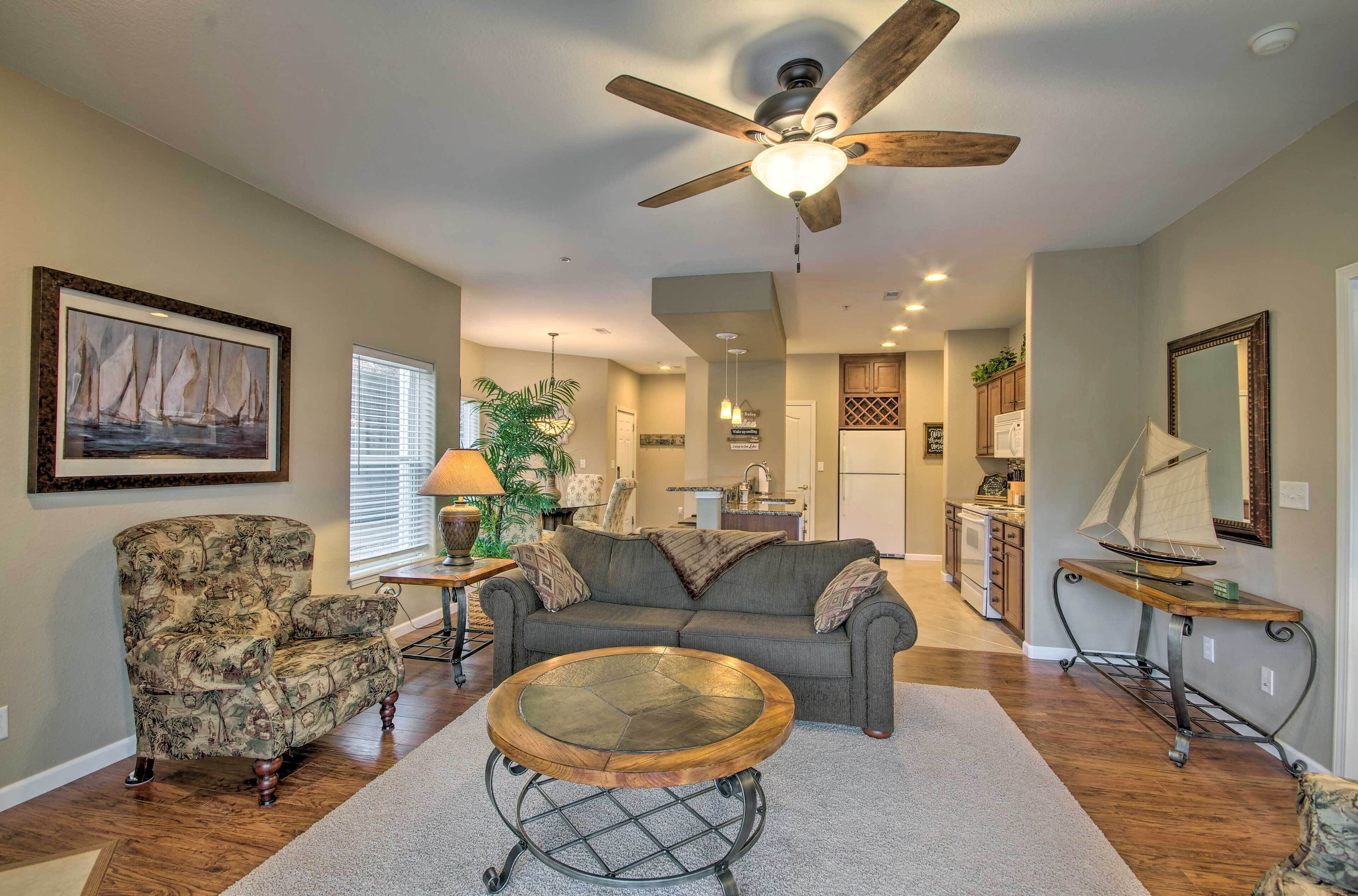 A living room with a ceiling fan, a round coffee table, a sofa, and a chair.