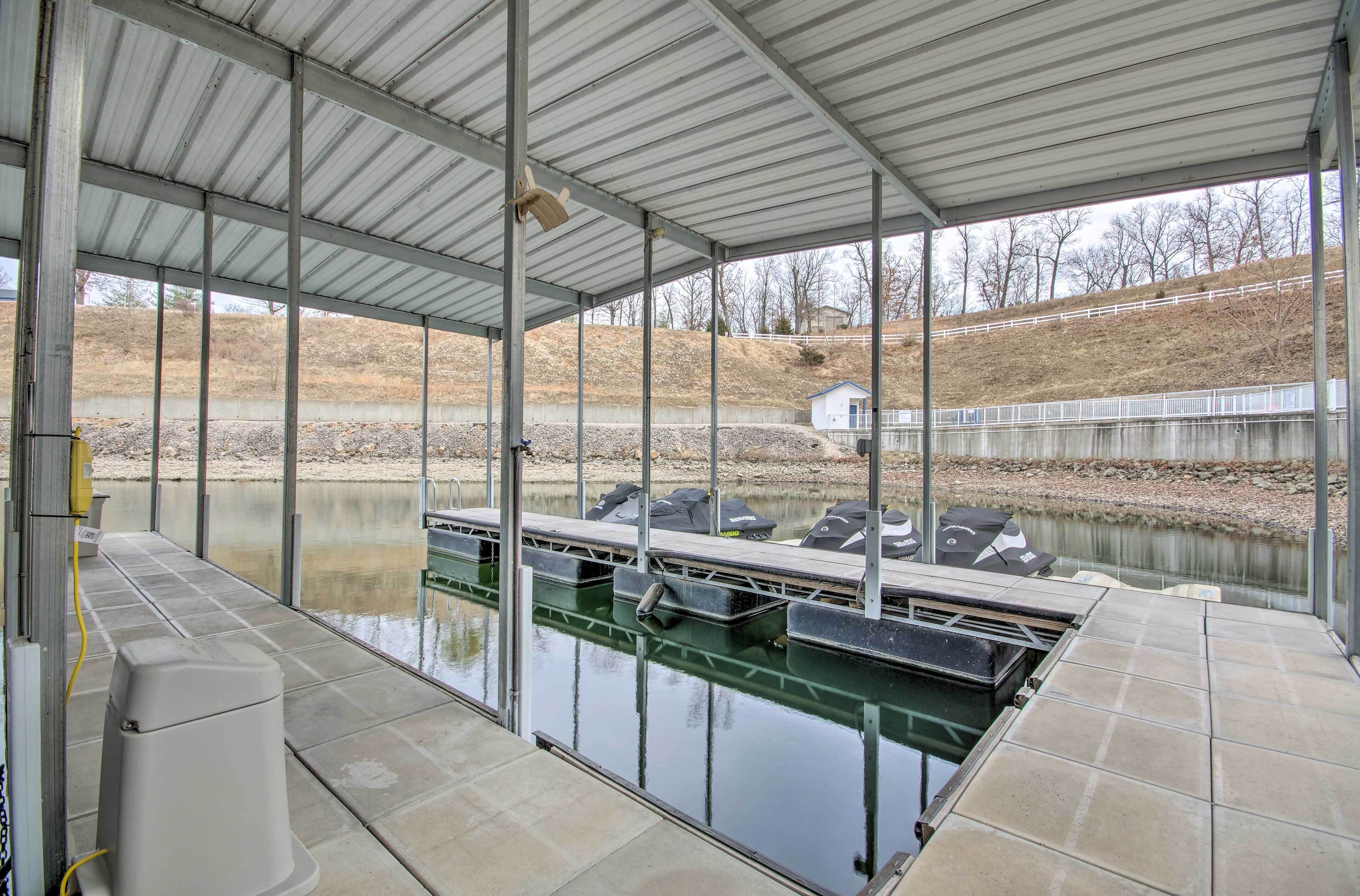 A covered outdoor area with a pool, seating, and a view of a hill.