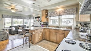 Una cocina moderna con una isla central, armarios de madera y un ventanal amplio.
