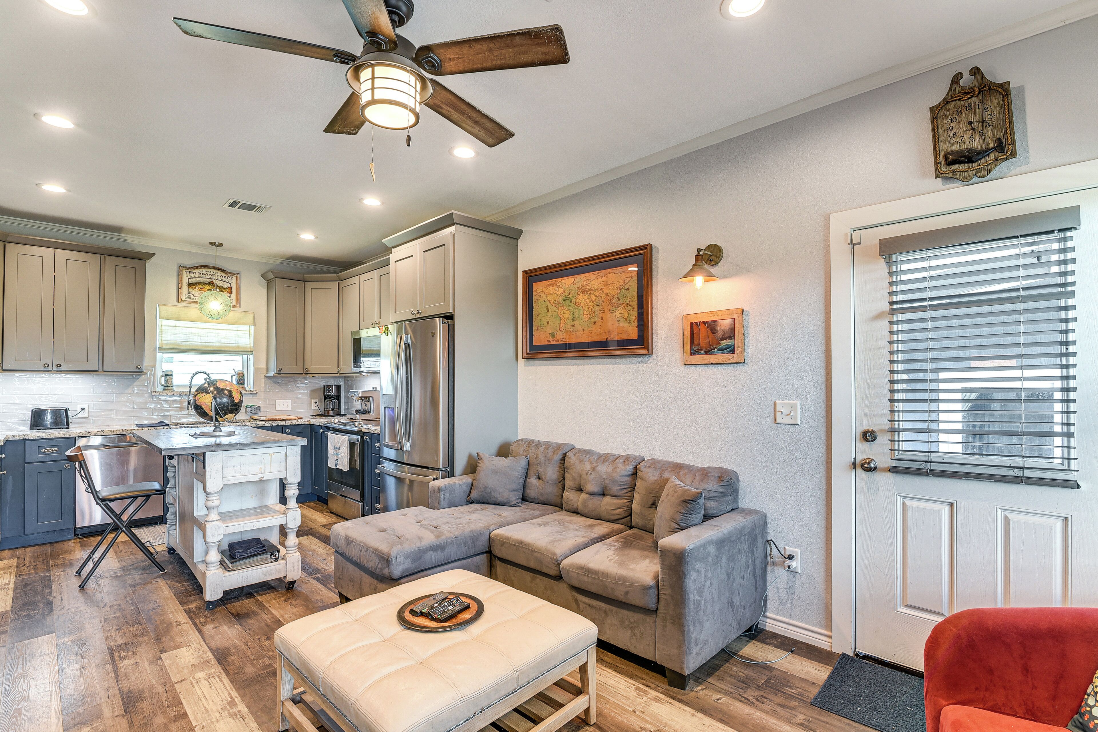 A spacious living area with a sectional sofa, a dining table, and a kitchen in the background.