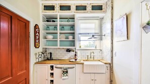 A compact kitchen with white cabinets, a wooden countertop, and a window with blinds. - Walk to Dtwn Shops & Eats: Sturgeon Bay Retreat (Sturgeon Bay)