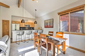 A modern kitchen with wooden cabinets, a central island, and bar stools. - Riverfront Silverthorne Condo Near Skiing! (Silverthorne)