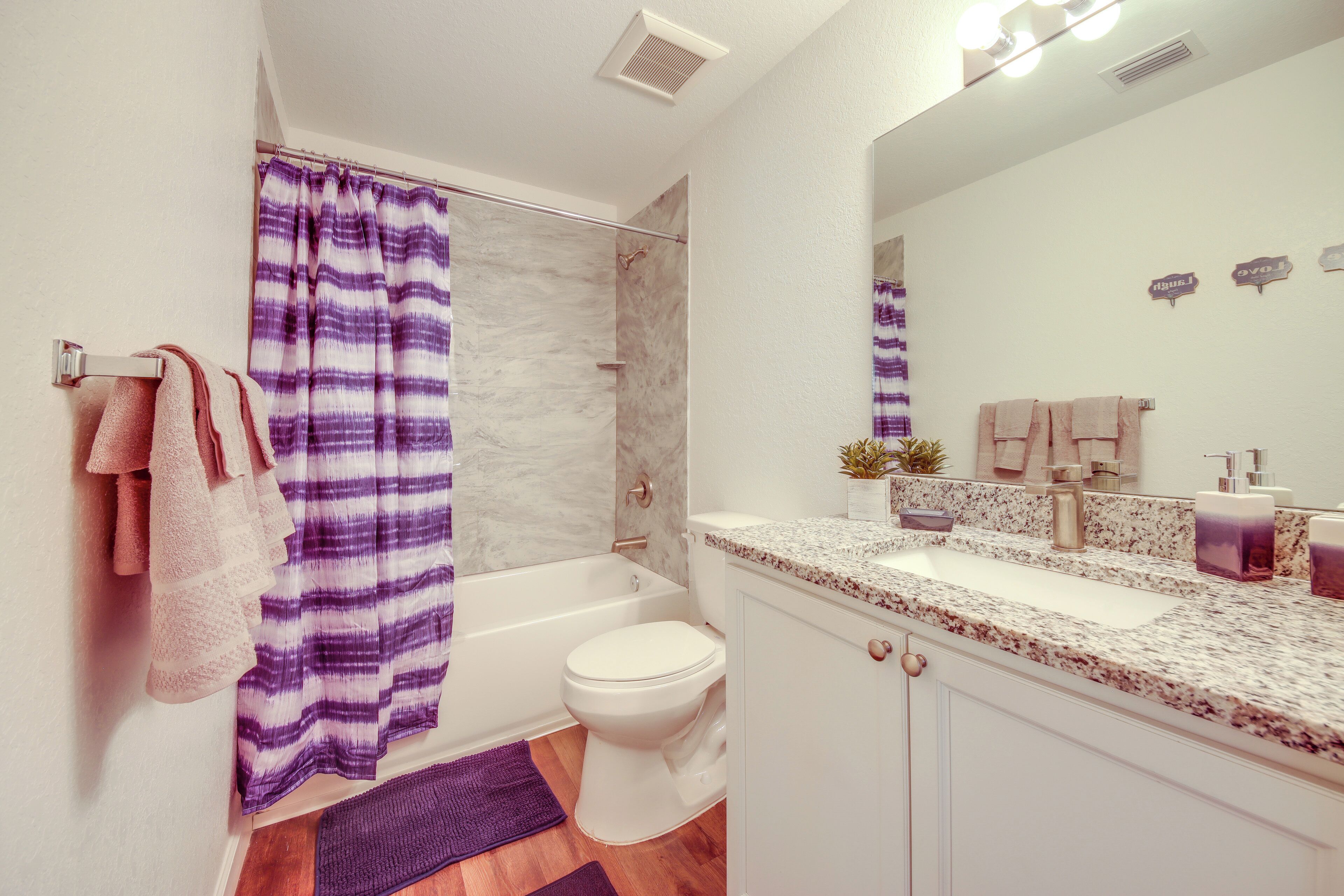 A bathroom with a shower, toilet, and sink.