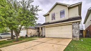 A two-story house with a garage, a driveway, and a lawn. - Spacious Houston Getaway < 18 Mi to Downtown! (Houston)