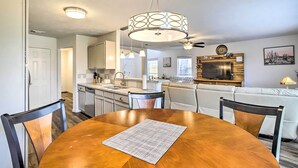 A modern kitchen with a dining area, featuring a wooden table, chairs, and a pendant light. - Spacious Houston Getaway < 18 Mi to Downtown! (Houston)