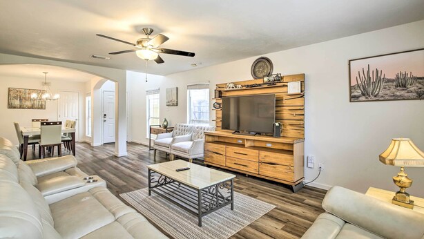 A spacious living room with a large sofa, a coffee table, and a TV on a wooden entertainment unit. - Spacious Houston Getaway < 18 Mi to Downtown! (Houston)