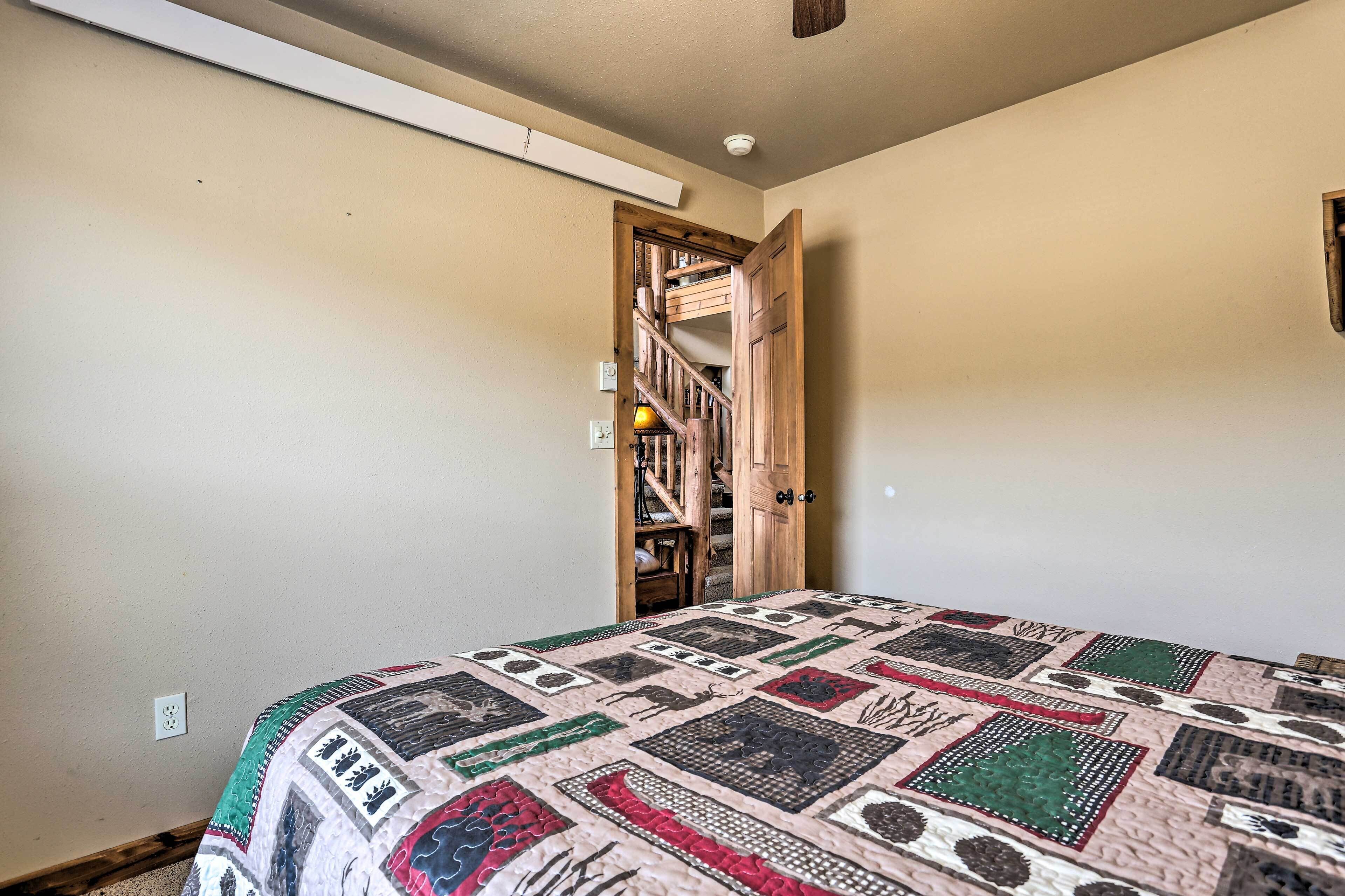 Une chambre avec un grand lit, un escalier en bois et une porte donnant sur un placard.