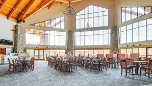 A spacious indoor dining area with high ceilings and large windows, featuring multiple dining tables and chairs. - Three Bears Resort Adventure Base w/ Lake Access (Warrens)