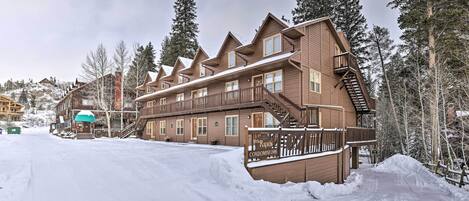 A large wooden building with multiple balconies and a staircase leading to the upper floors.