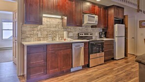 Una cocina moderna con armarios de madera, electrodomésticos de acero inoxidable y un salpicadero de ladrillo.