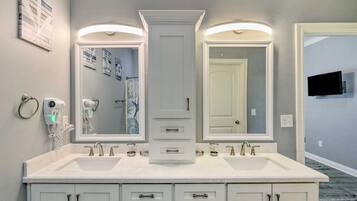 A bathroom with a double vanity, two sinks, and a large mirror.