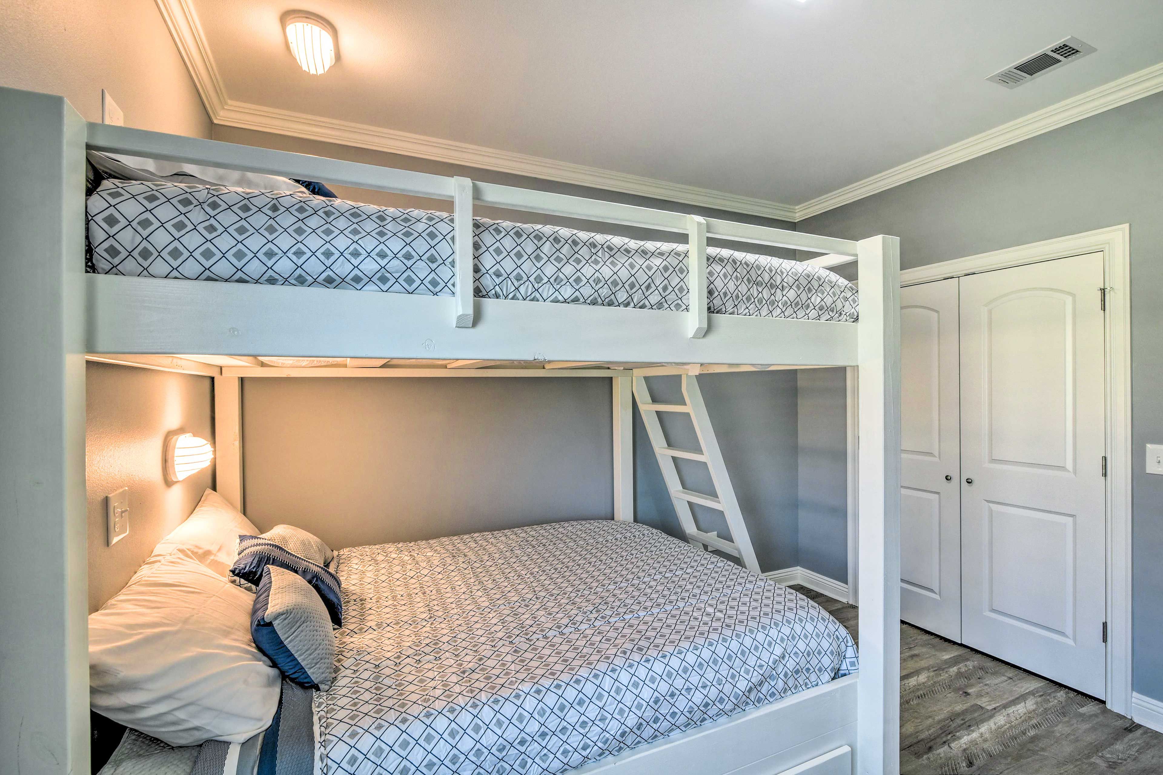 A bunk bed with a ladder, a bedside table, and a nightstand.