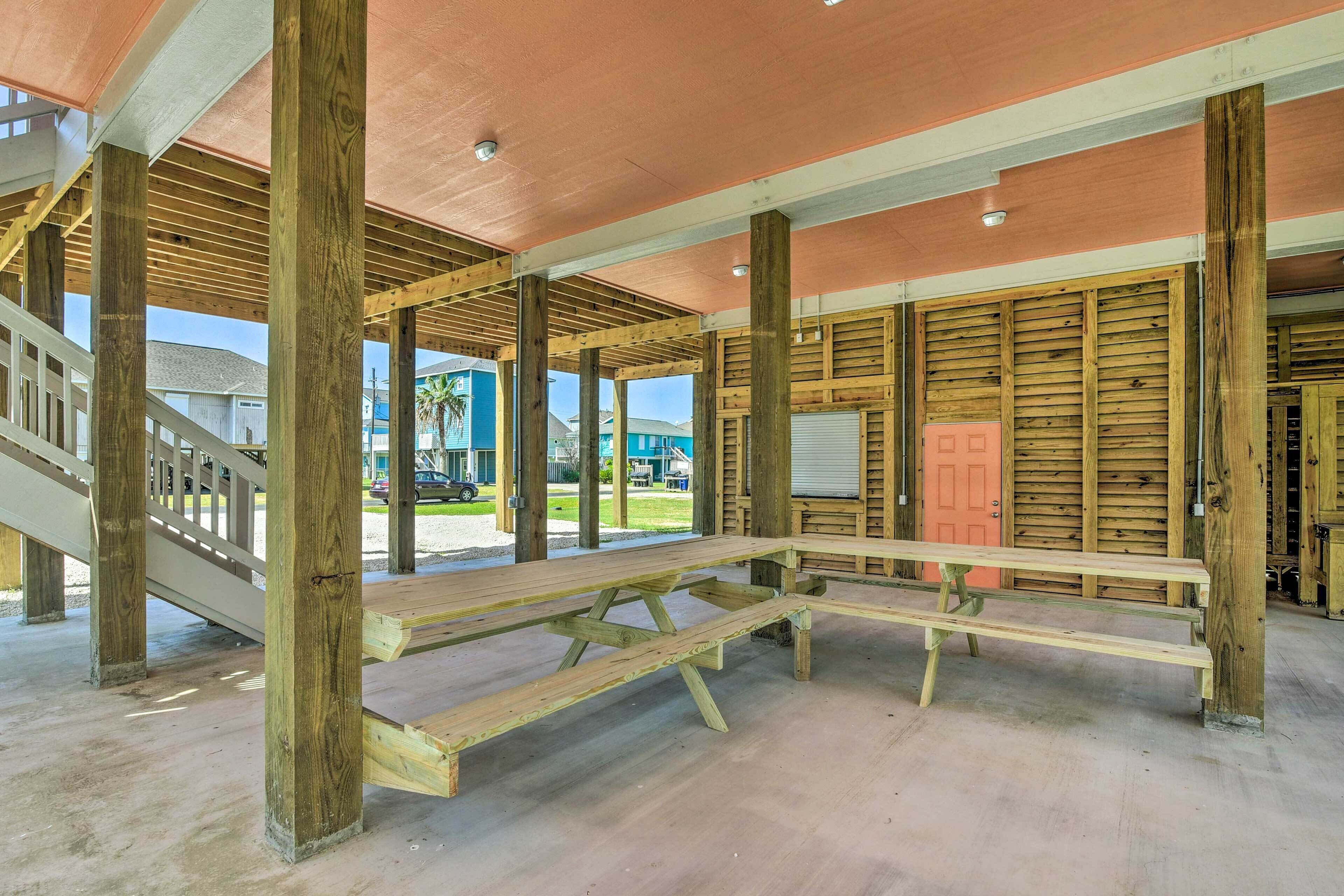 A covered outdoor area with wooden benches and a staircase.
