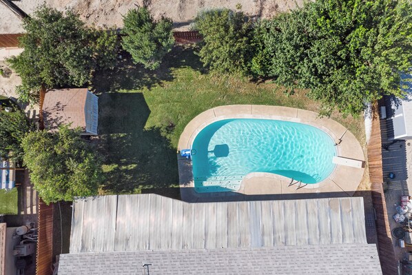 An aerial view of a swimming pool surrounded by trees and a fenced area. - Indio Home w/ Pool: 2 Mi to Coachella! (Indio)
