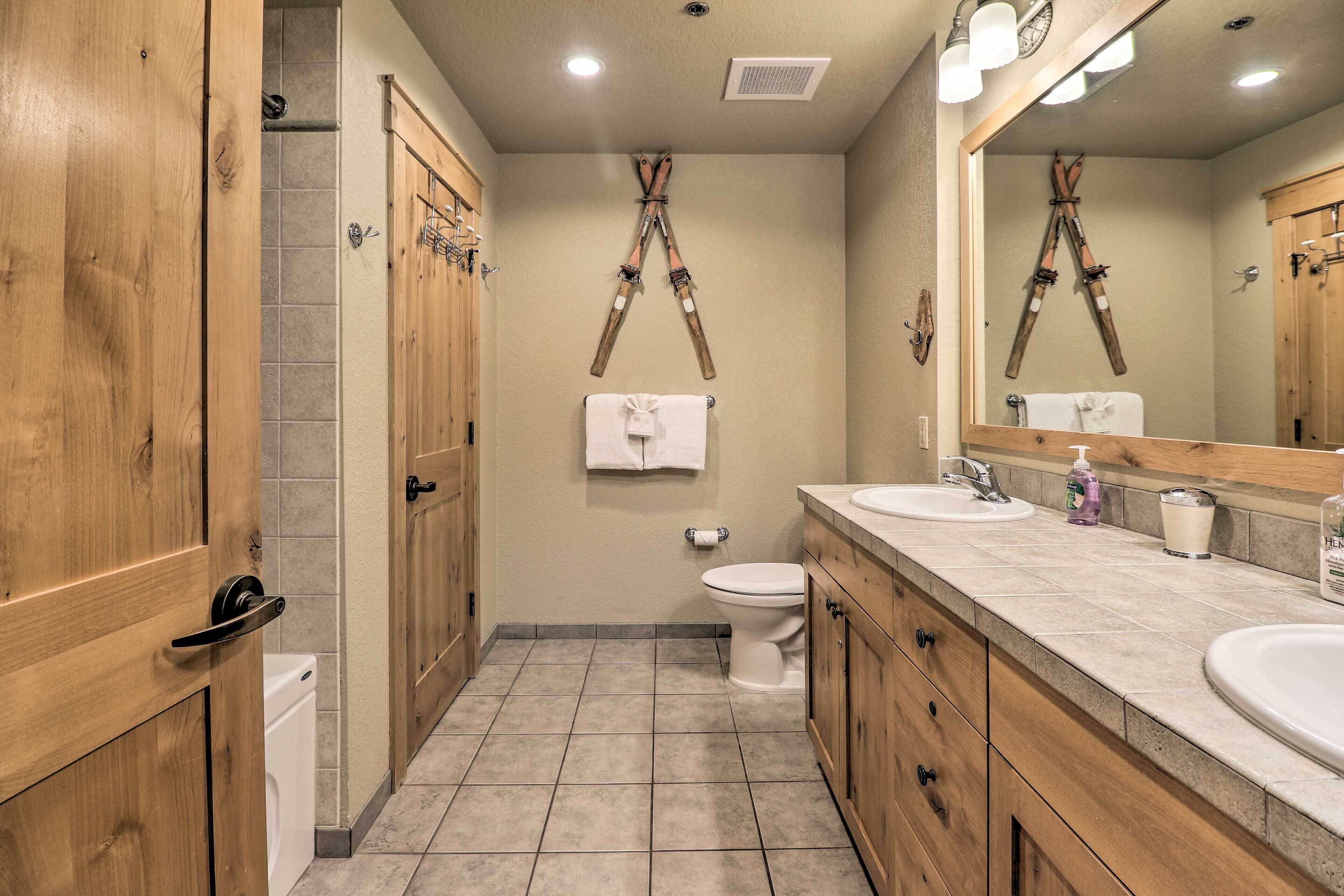 A bathroom with wooden cabinets, a white toilet, and a large mirror.