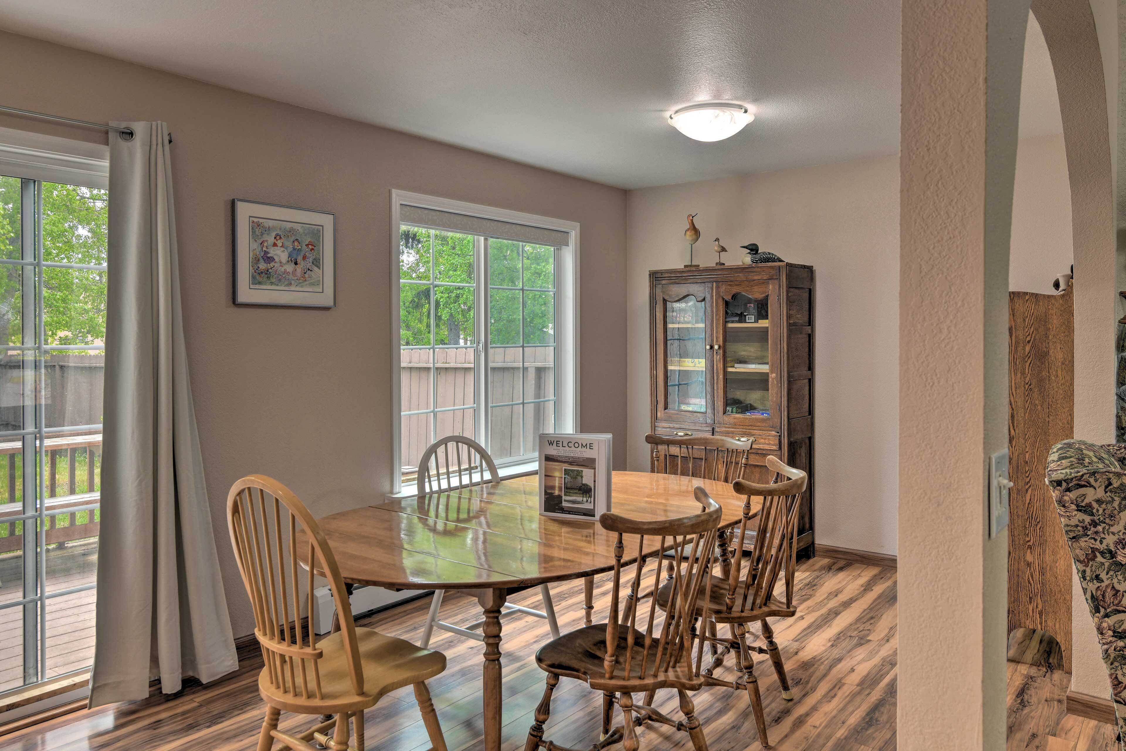 A dining area with a wooden table and chairs, a cabinet, and a framed picture on the wall.