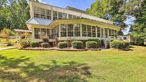 A two-story house with a large bay window, a covered porch, and a well-maintained lawn. - 'the B Haus' Lakefront Retreat w/ Boat Ramp! (Talladega)