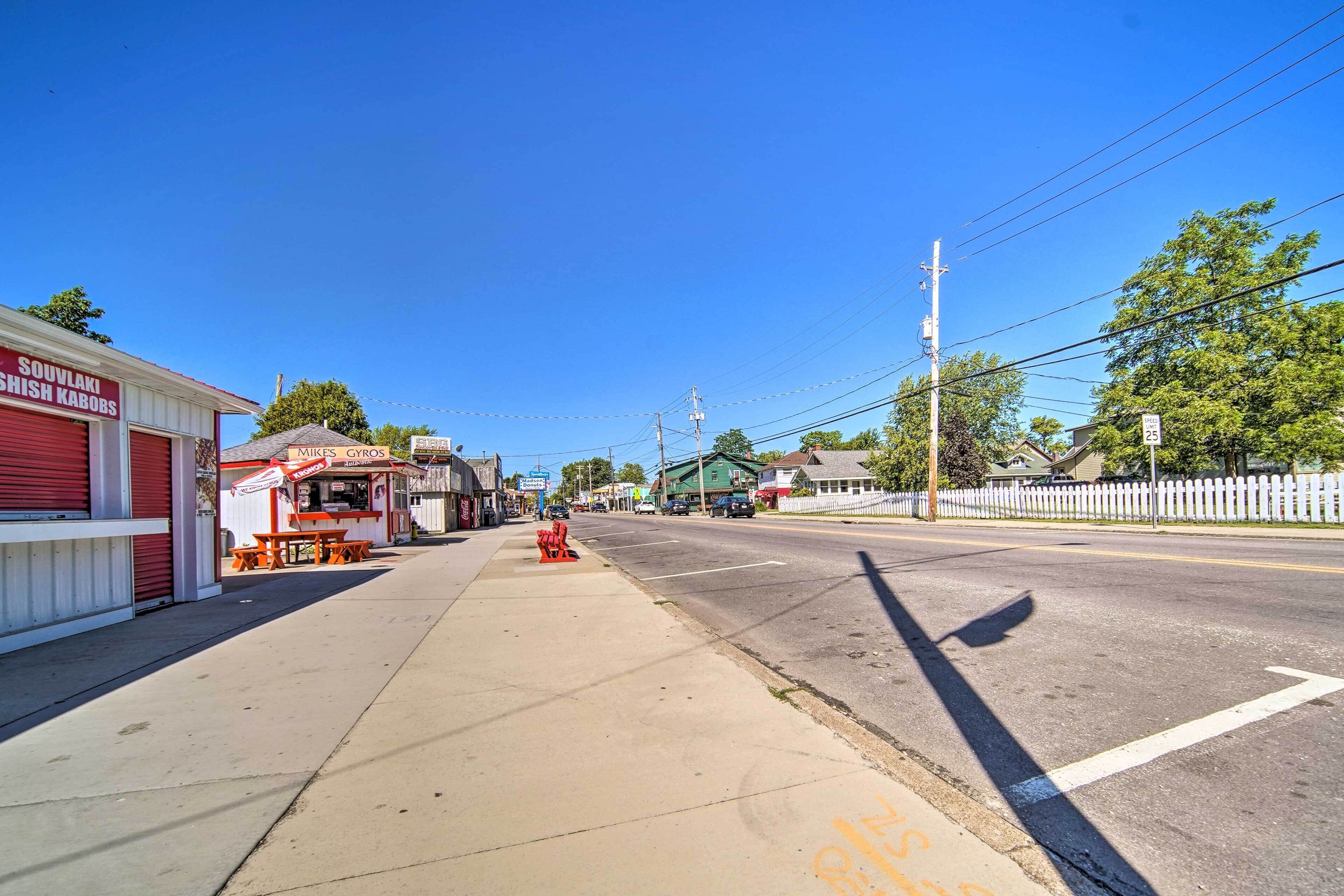 A street view with a sidewalk, storefronts, and a fire hydrant.