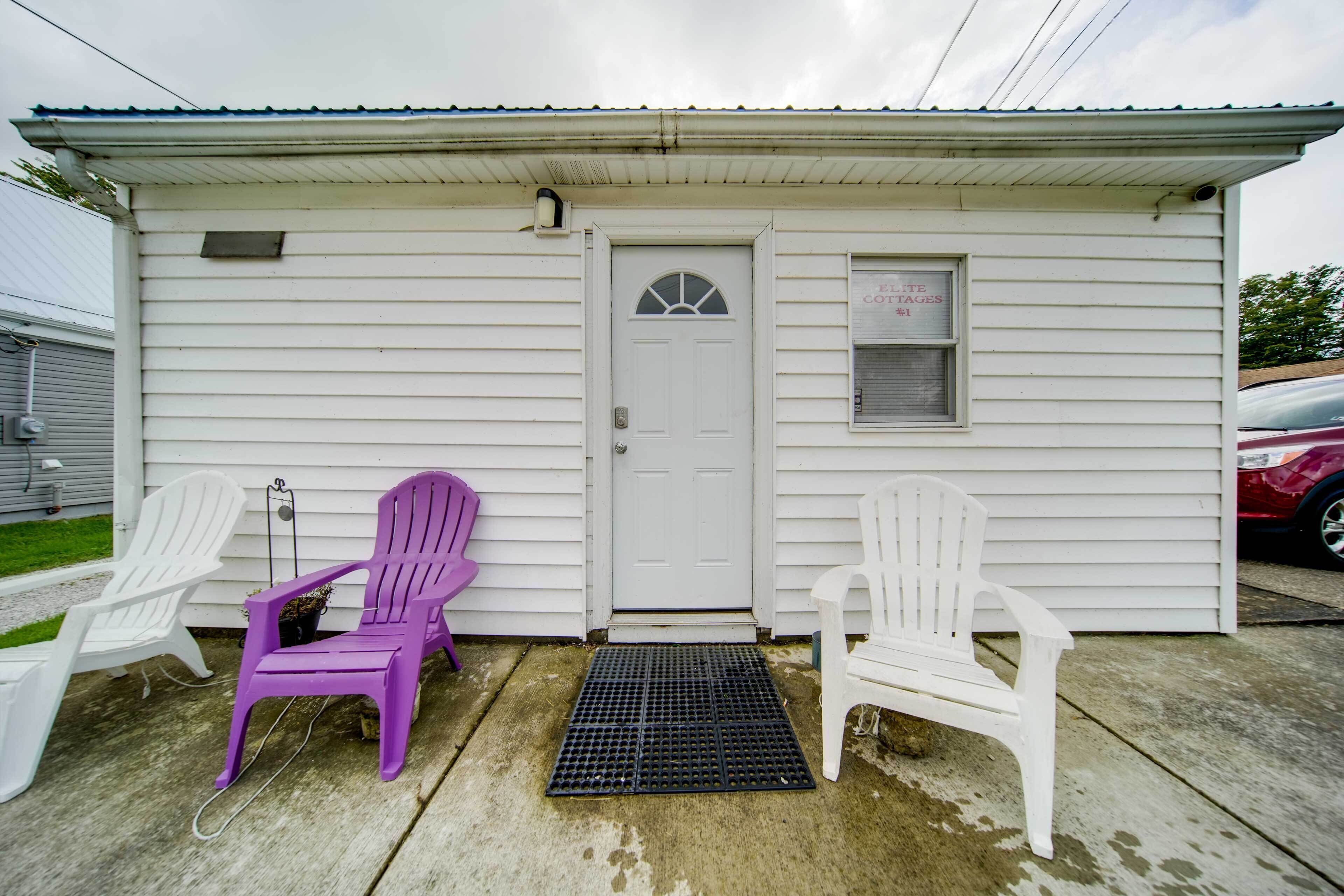 A small white building with a door and a window displaying "ELECTRIC COTAGES."