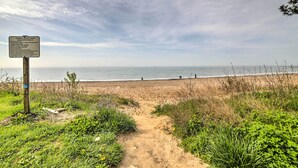 Un sentiero sulla spiaggia che conduce all'oceano, con un cartello.