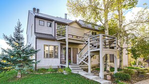 A two-story house with a front porch, a staircase, and a small garden.