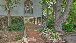 Un espace extérieur abrité, doté d’un chemin en pierre menant à un bâtiment avec une grande fenêtre en arc de cercle.