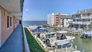 Ein Yachthafen mit vertäuten Booten, ein Gebäude am Wasser und eine Uferpromenade.