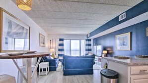 Eine moderne Küche mit Essbereich, ausgestattet mit einem blauen Sofa, einem kleinen Tisch und einem Papierkorb.