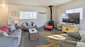 Un salon chaleureux avec un canapé, une table basse, un téléviseur et une cheminée.
