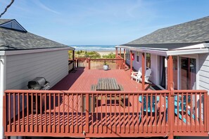 A deck with a view of the beach, a barbecue grill, and a covered area with chairs. - Rockaway Beach Vacation Rental: Pets Welcome! (Rockaway Beach)
